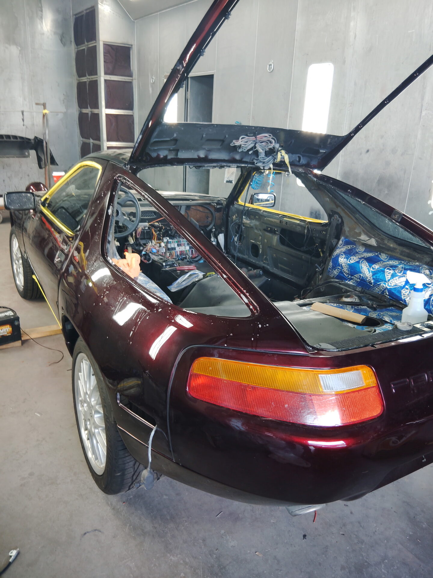 Maroon Porsche 928 in the paint booth